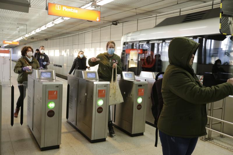 Un voluntario de la DYA entrega mascarillas a la entrada de la estación de La Arenas.