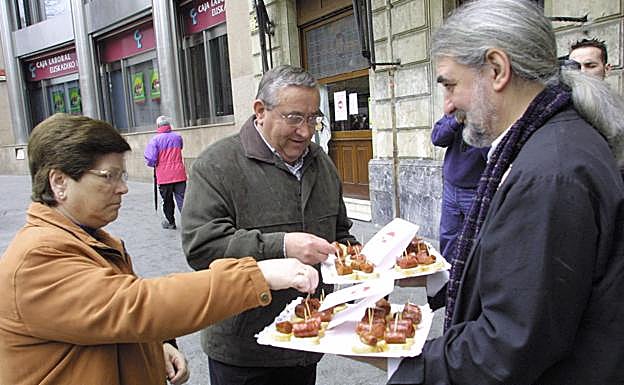 El fundador de la asociación, Marino Montero, reparte tapas elaboradas con partes del cerdo. 