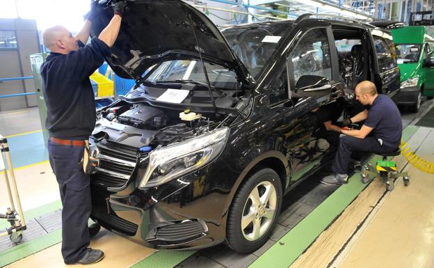 Dos operarios montan un vehículo en la línea de producción de Mercedes.