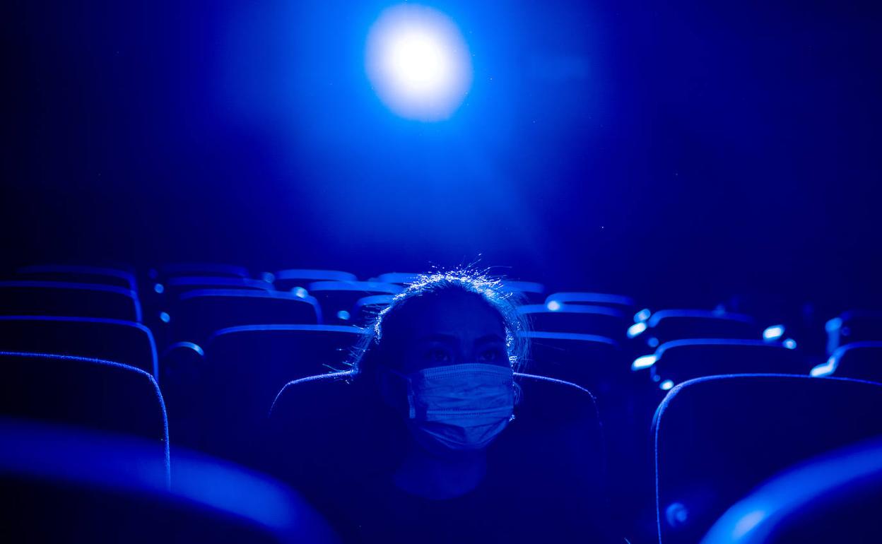 Una espectadora con mascarilla en un cine asiático.