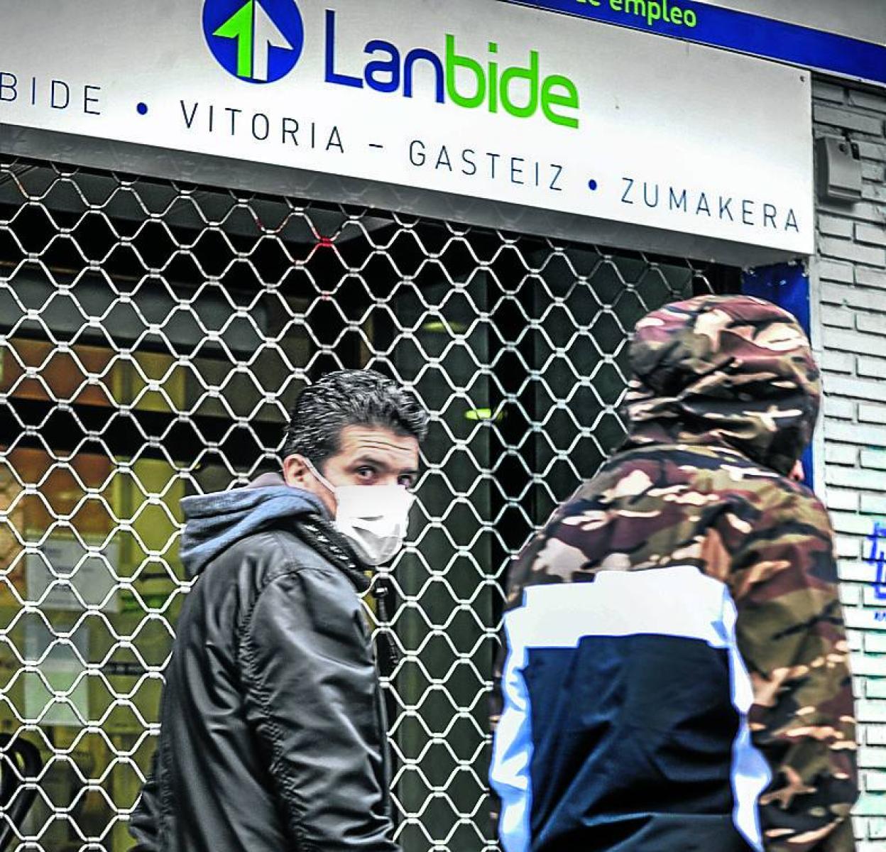 Dos jóvenes pasan ante una oficina de Lanbide en Vitoria. 