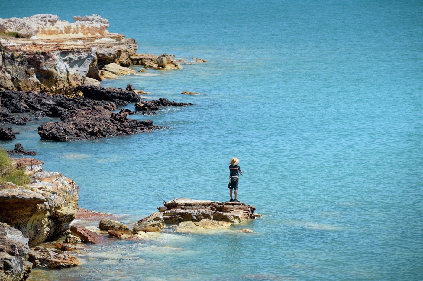 Un hombre pesca entre las rocas en la costa de Darwin (Australia). El Territorio del Norte se ha convertido en la primera región australiana en aligerar las restricciones para combatir la pandemia de COVID-19. 