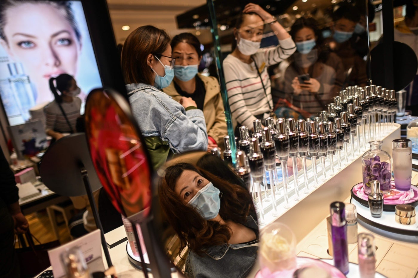 Clientes con máscaras faciales visitan un centro comercial durante el día festivo por el 1 de mayo en Shanghai. - Con optimismo y una fuerte dosis de precaución, millones de chinos salieron a la carretera o visitaron sitios turísticos recientemente reabiertos el 1 de mayo para un feriado nacional extendido en una prueba de confianza posterior al coronavirus. 