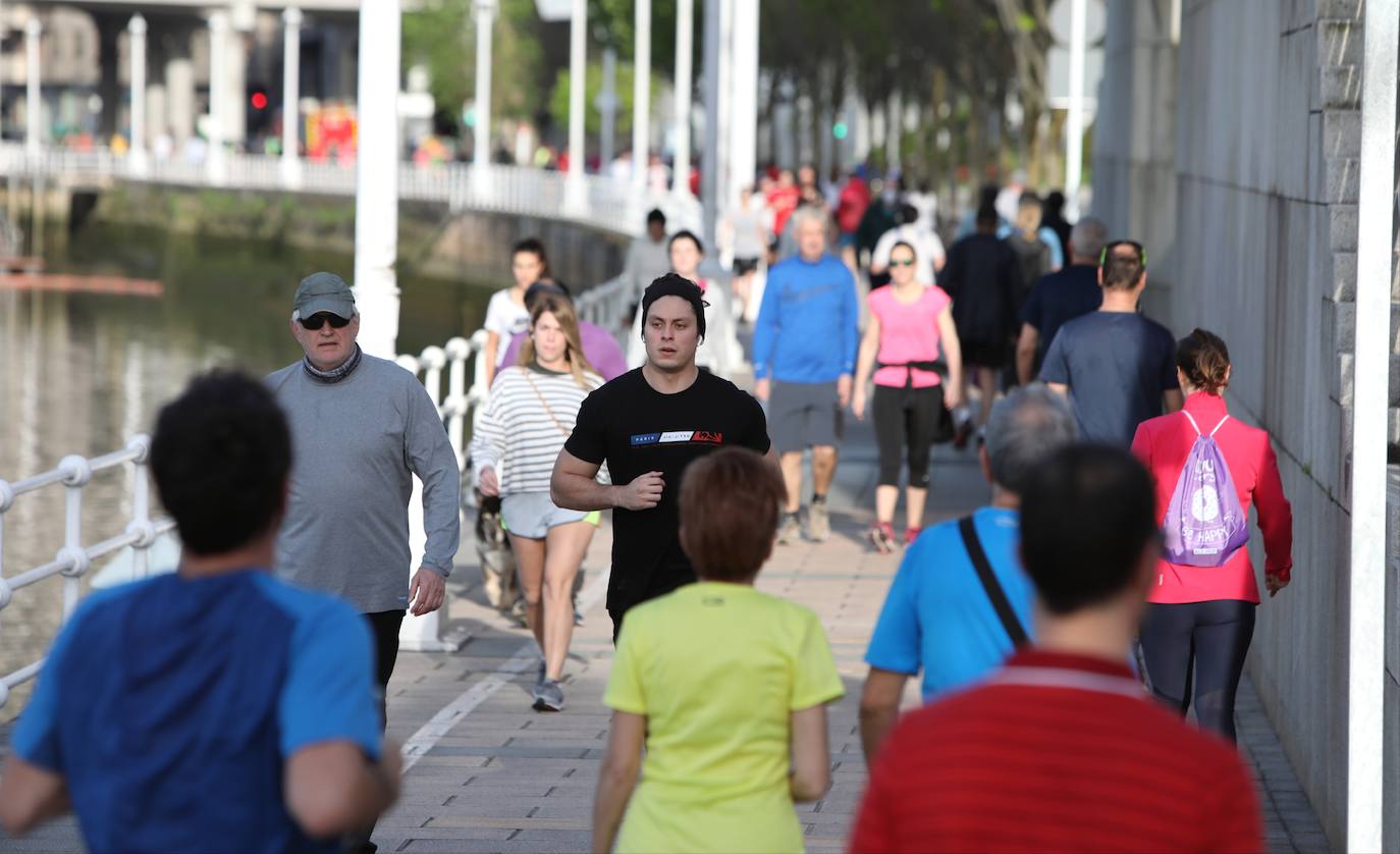 La gente corre y pasea por Bilbao.