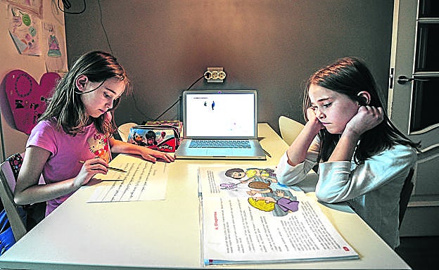 Dos niñas de 7 años trabajan en casa durante el confinamiento.
