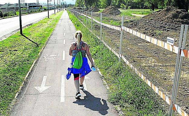 Una mujer camina por el bidegorri de Avenida del Zadorra, estrechada por las obras.