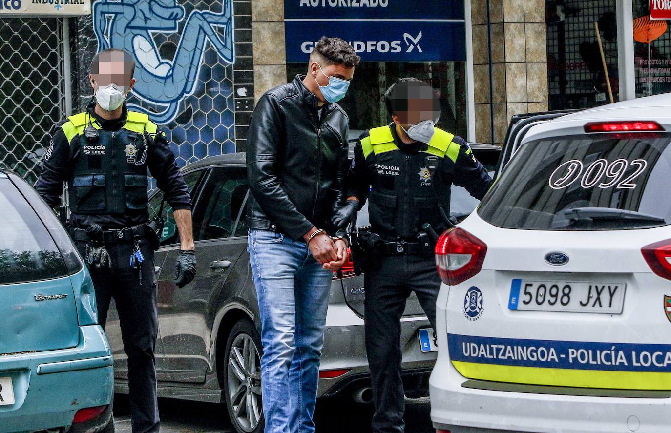 Agentes locales conducen al sospechoso a un coche patrulla tras finalizar el registro de su casa. 