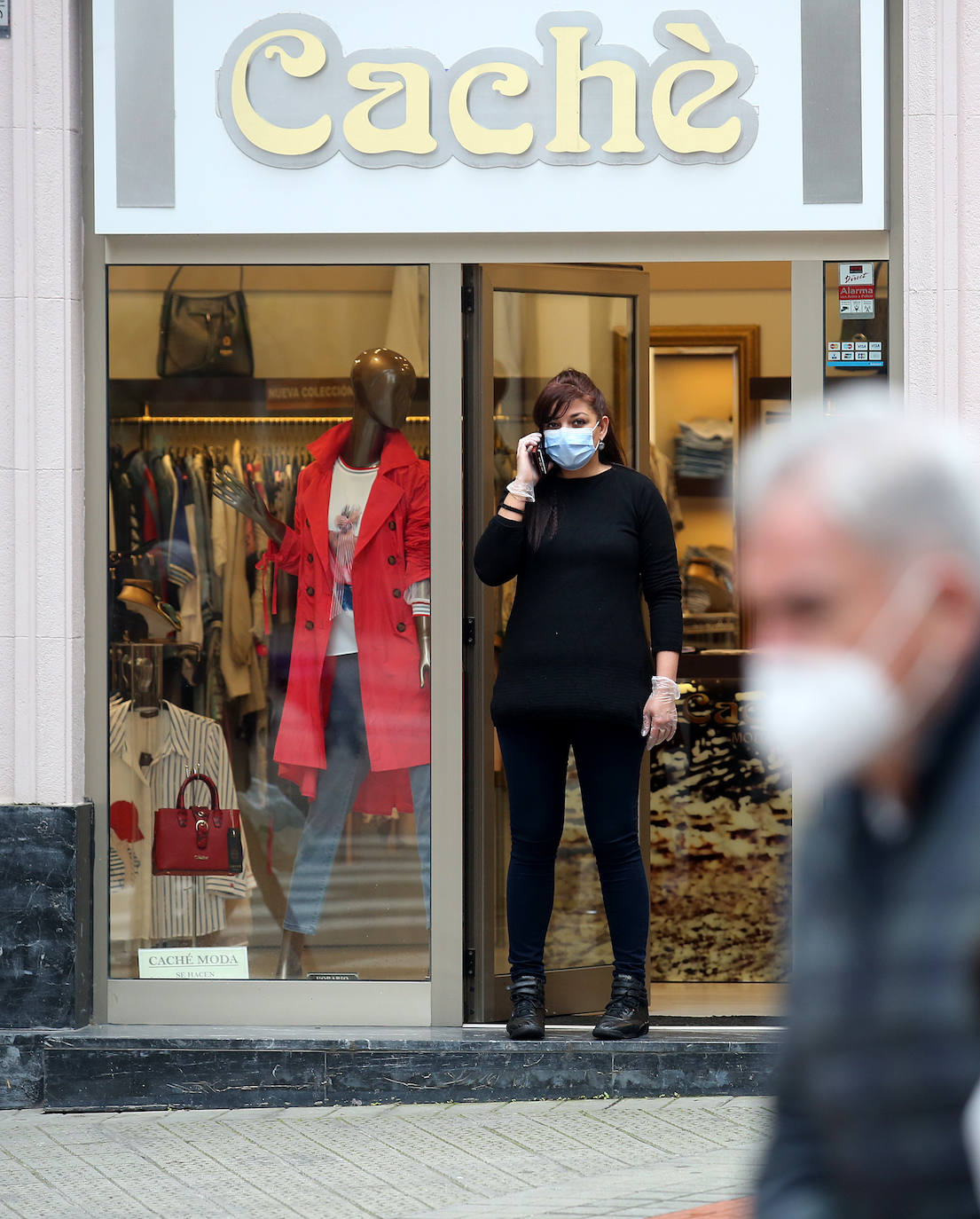 Una dependienta en la puerta de la tienda.