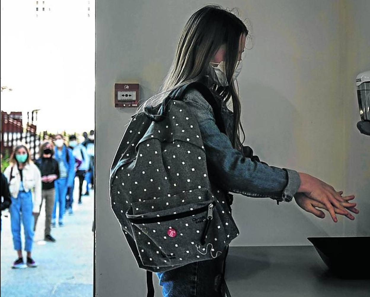 Una alumna se desinfecta las manos en un centro educativo de Francia. 