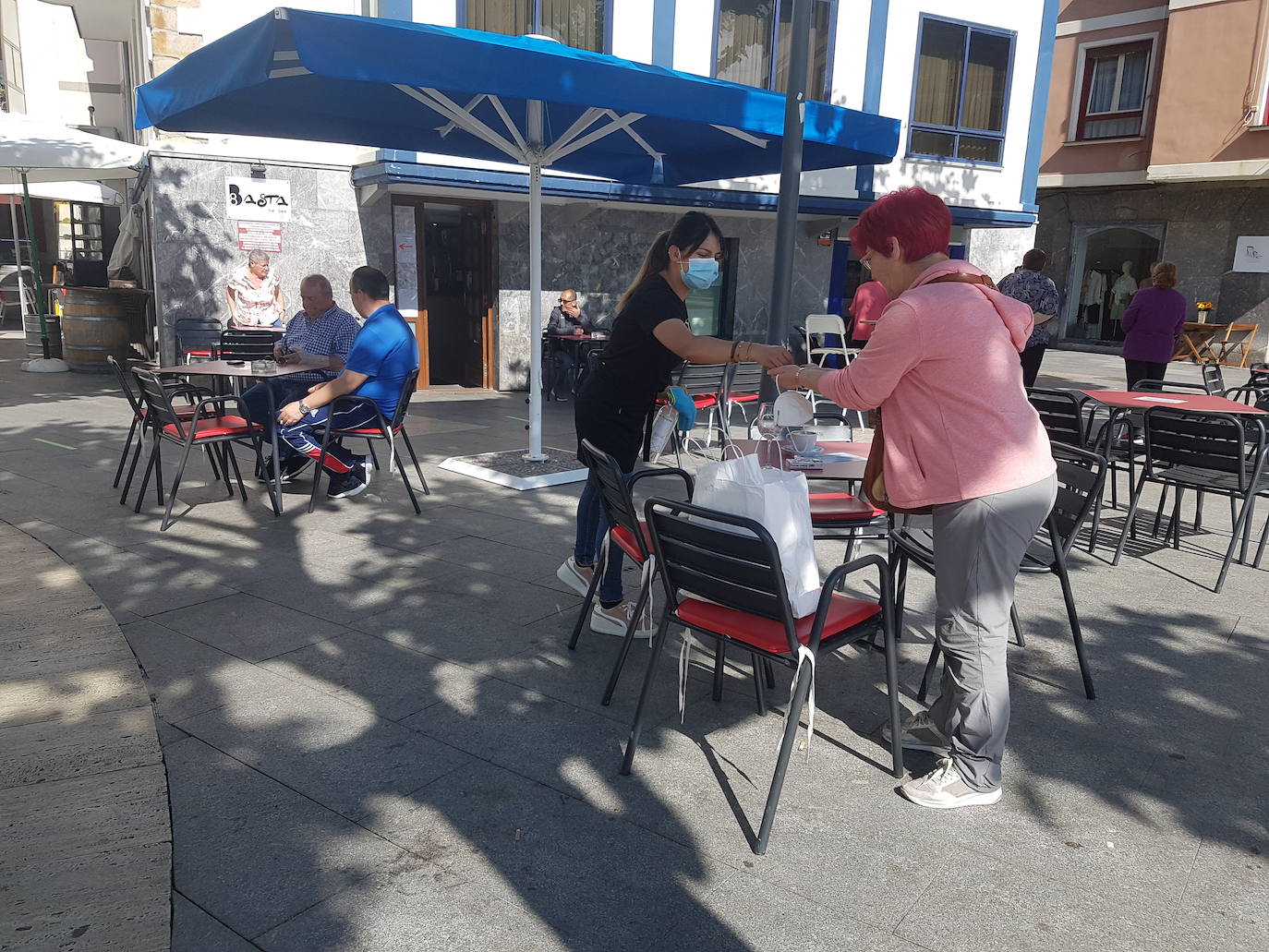 Toda precaución es poca contra el contagio del Coronavirus. "Tenemos que limpar las mesas después de cada servicio de manera concienzuda, sin bajar la guardia", comenta Daniela Oliveira, la camarera de la terraza del bar 'Con 8 basta' de Bermeo. Las mesas de la minúscula taberna situada en el parque de la Lamera de la localidad llevan pegado un cartel en el que recomiendan a los clientes, "que procuren no moverlas de sitio, aunque siempre hay alguno que no lo puede evitar", señala Alex, el propietario del negocio. Informa Iratxe Astui.