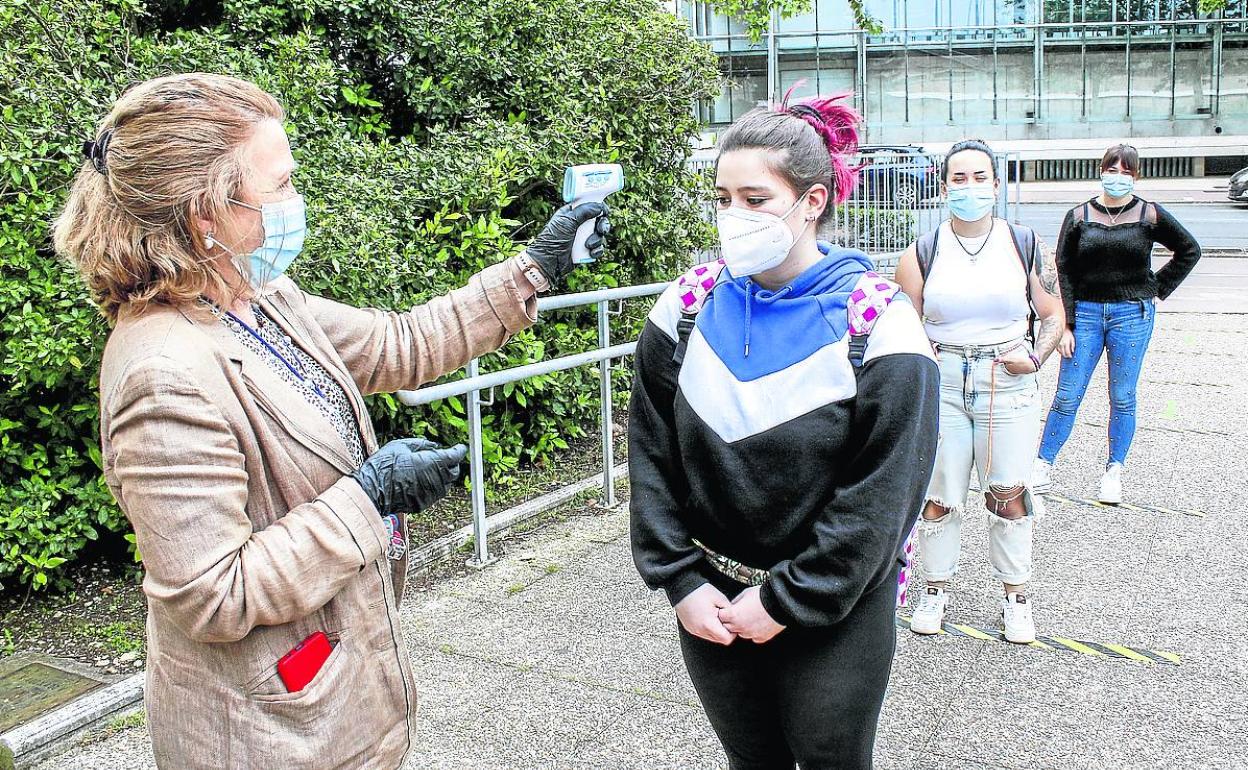 La responsable de un centro educativo de Vitoria toma la temperatura a una alumna. 