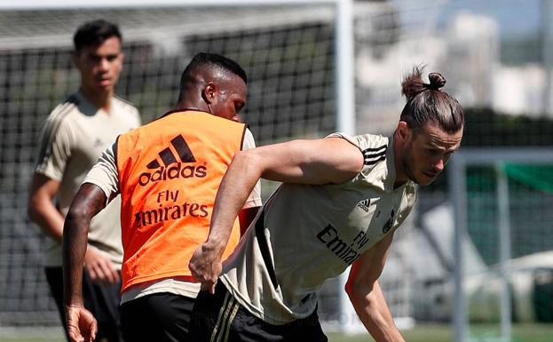 Bale disputa un balón con Vinicius. 