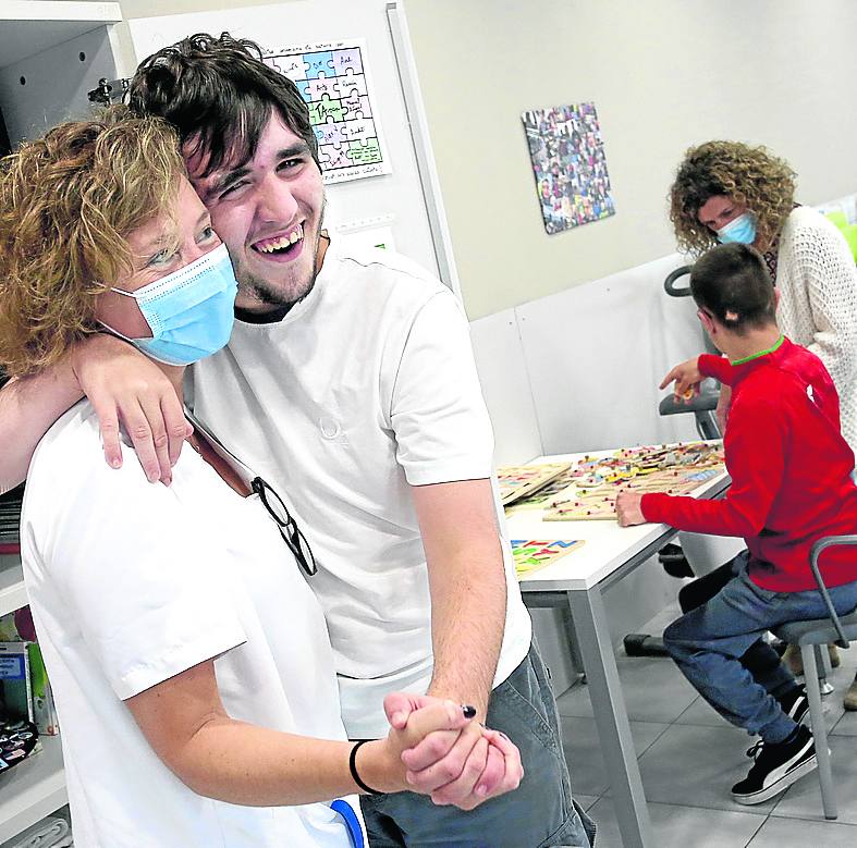 Uno de los usuarios se abraza a una de las trabajadoras del taller. 