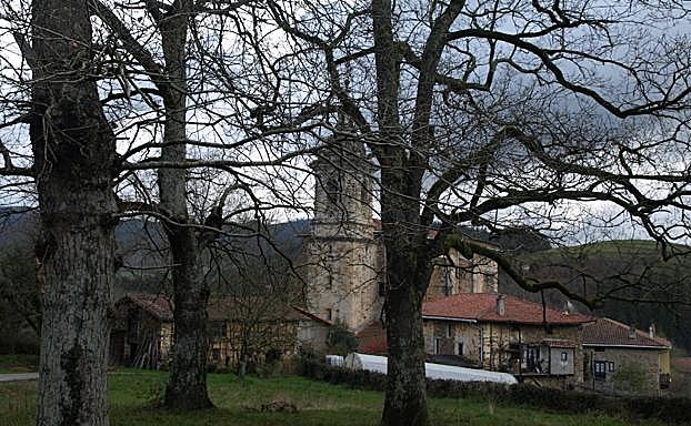 La silueta de Ermitabarri (Zeberio) se vislumbra entre los árboles. 
