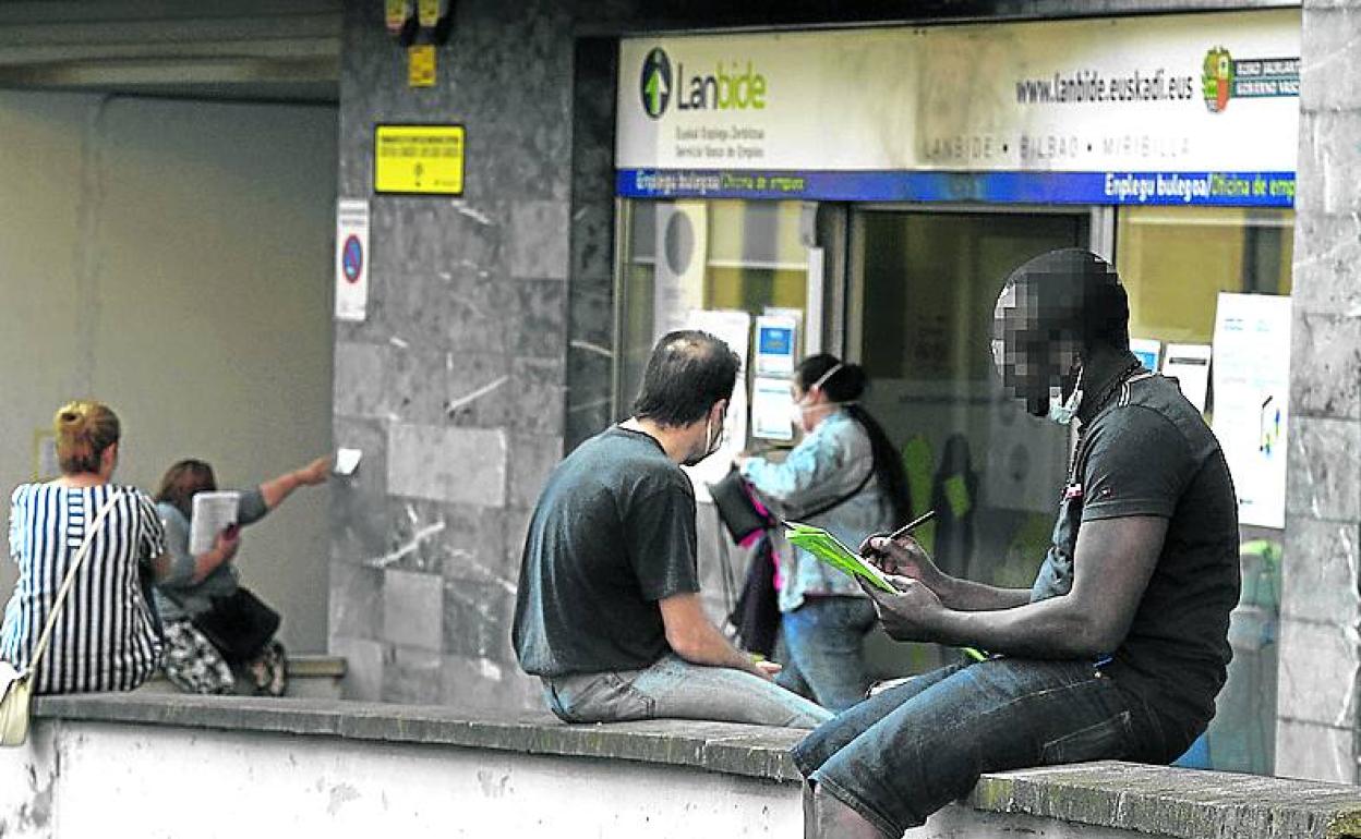 Unas personas aguardan ante una oficina de Lanbide. 