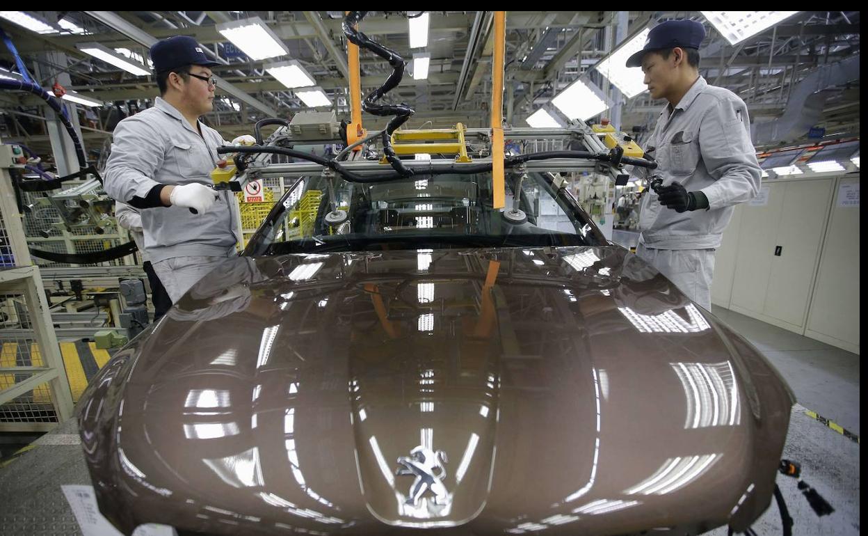 Trabajadores en la planta de Peugeot Citroen en Wuhan, China.