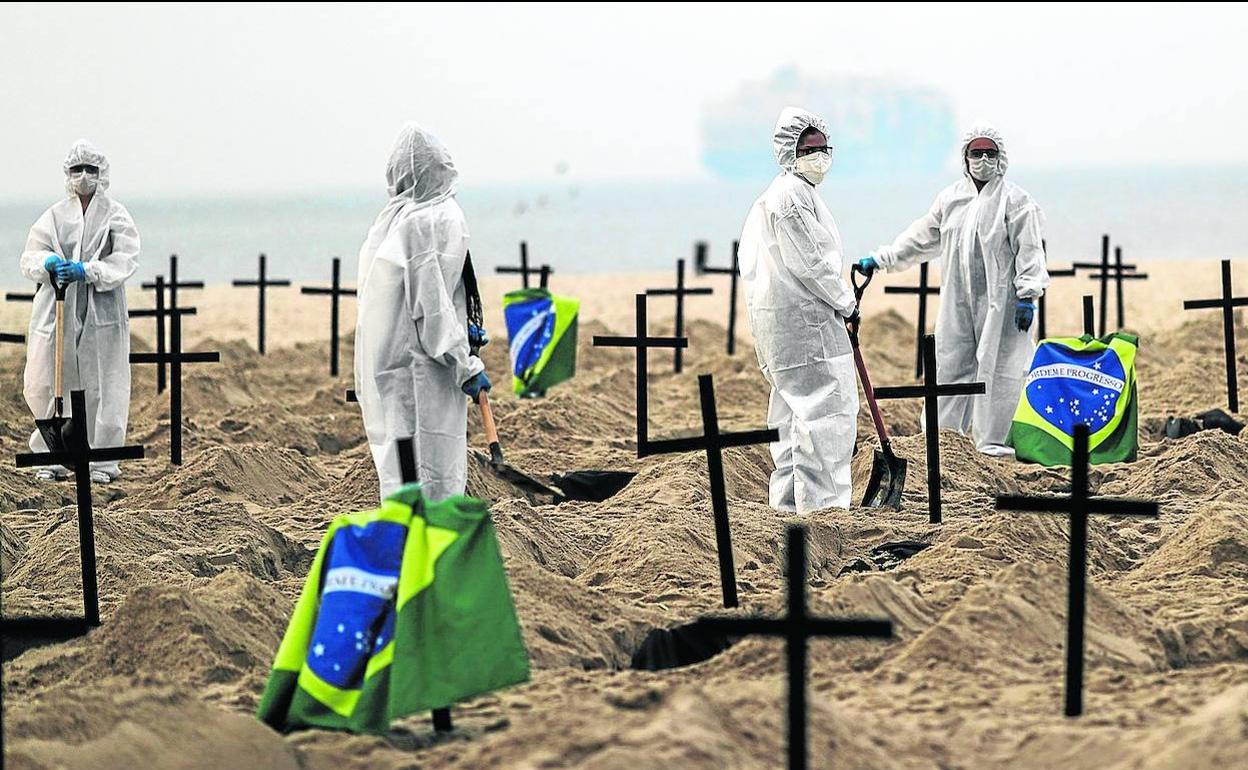 Activistas colocan cruces en una playa de Río de Janeiro para denunciar los errores del Gobierno en la gestión de la pandemia. 