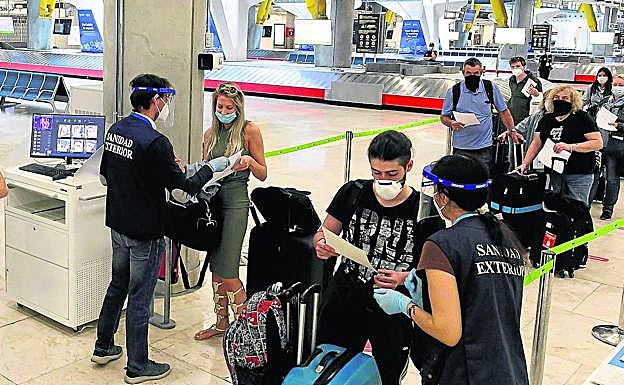 Personal del aeropuerto de Barajas supervisa la entrada de pasajeros, a los que se les entregó una guía para mantener las medidas de seguridad. 