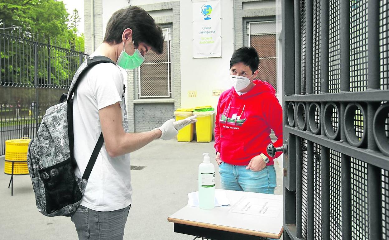 Un estudiante y una profesora en la entrada del colegio Urkide.