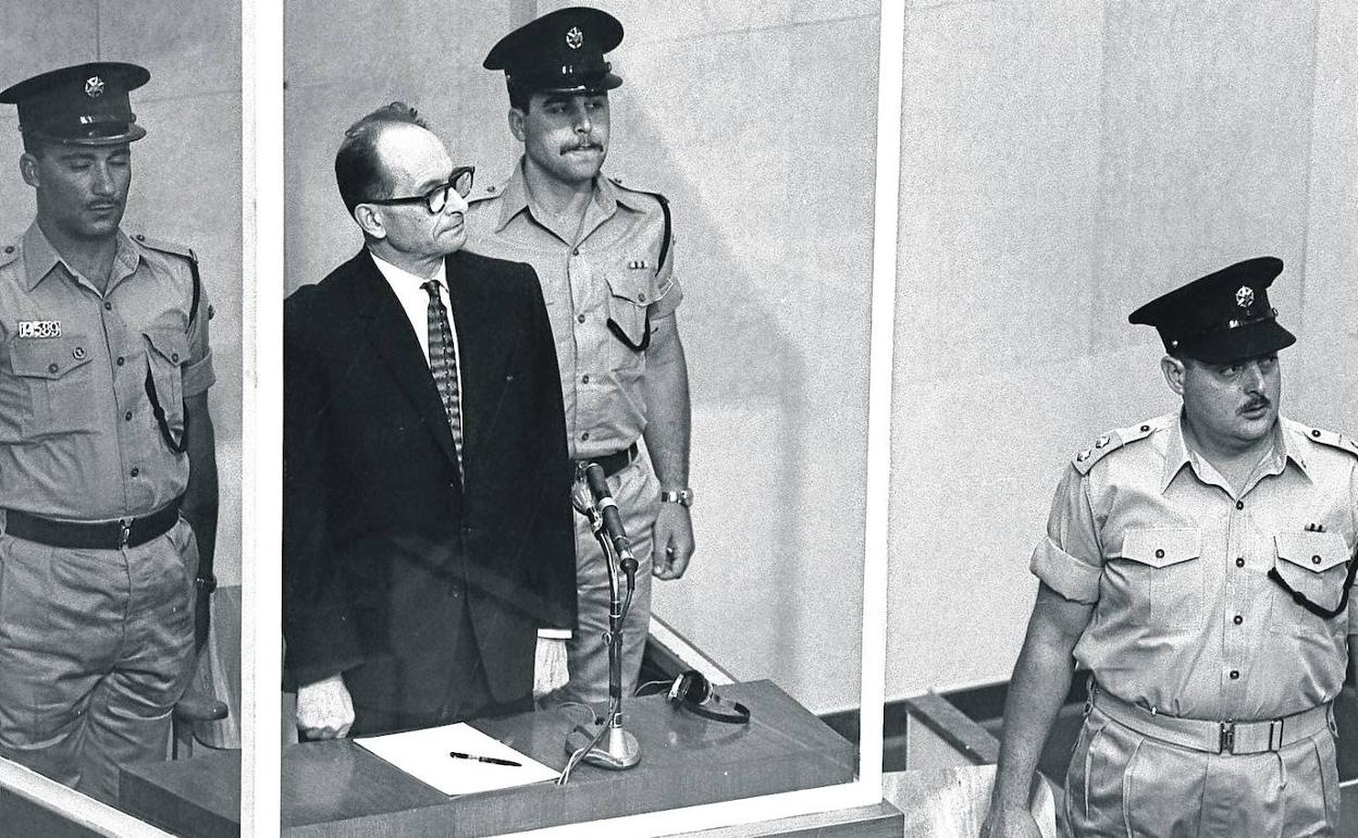 Juicio a Eichmann. El líder nazi, en el proceso en Jerusalén, en 1961. Debajo el carné de voluntario de Demjanjuk. 