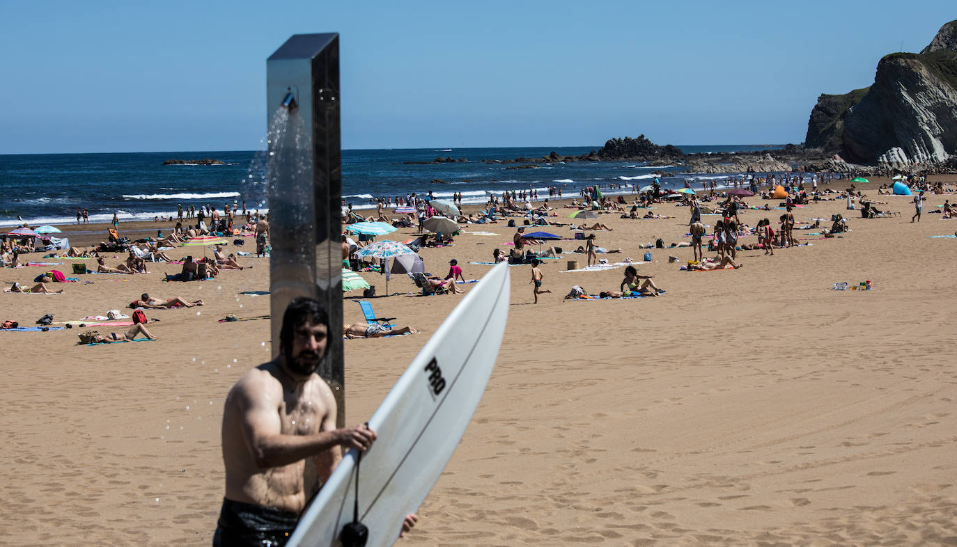 Un surfista se ducha en Sopela