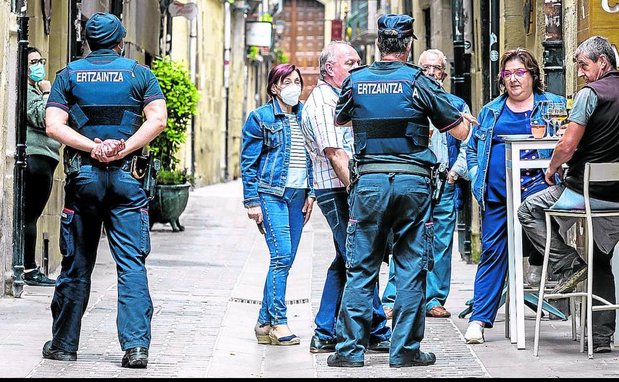 Una patrulla de la Ertzaintza charla con varios vecinos en la calle Mayor de Laguardia.