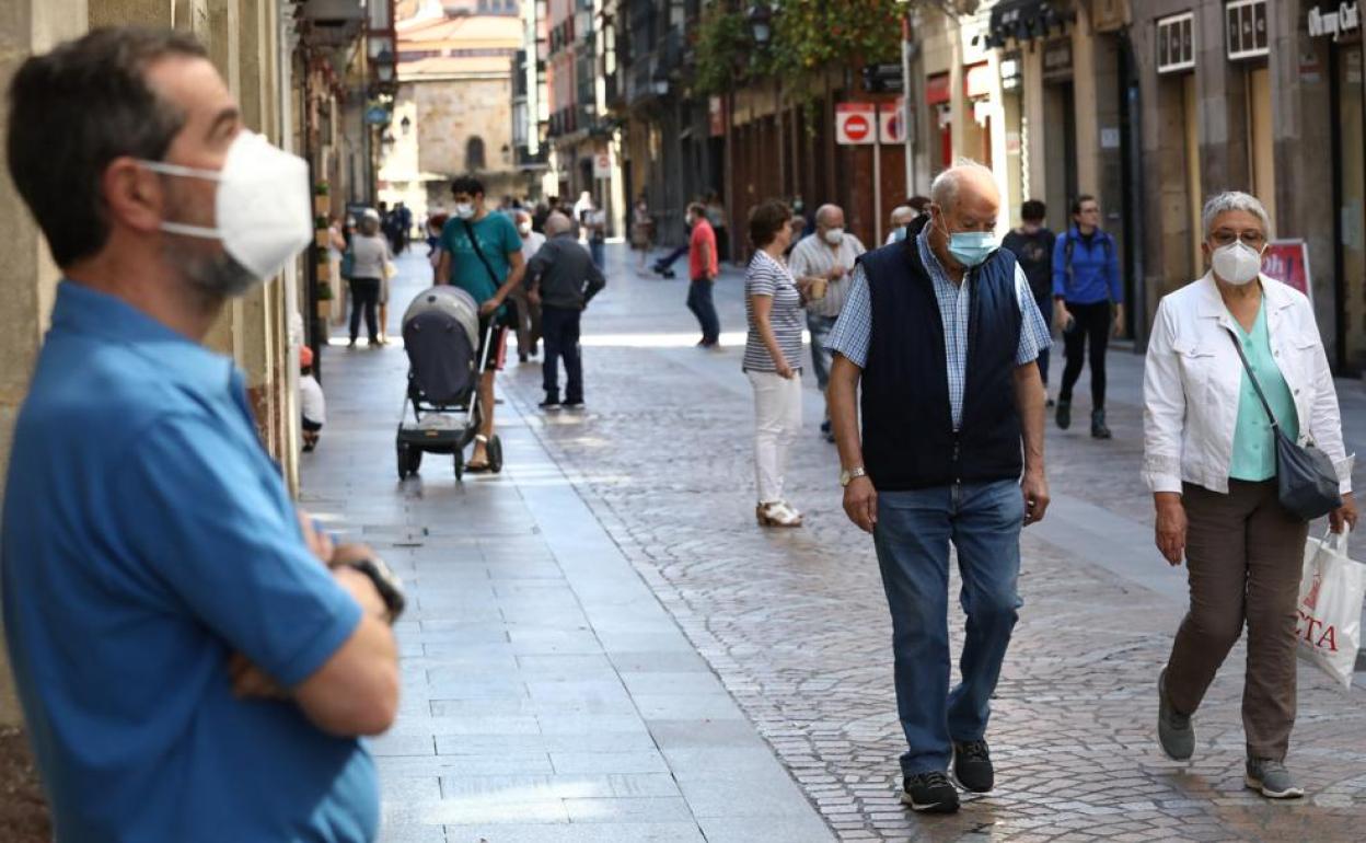 Varias personas caminan por el centro de Bilbao.