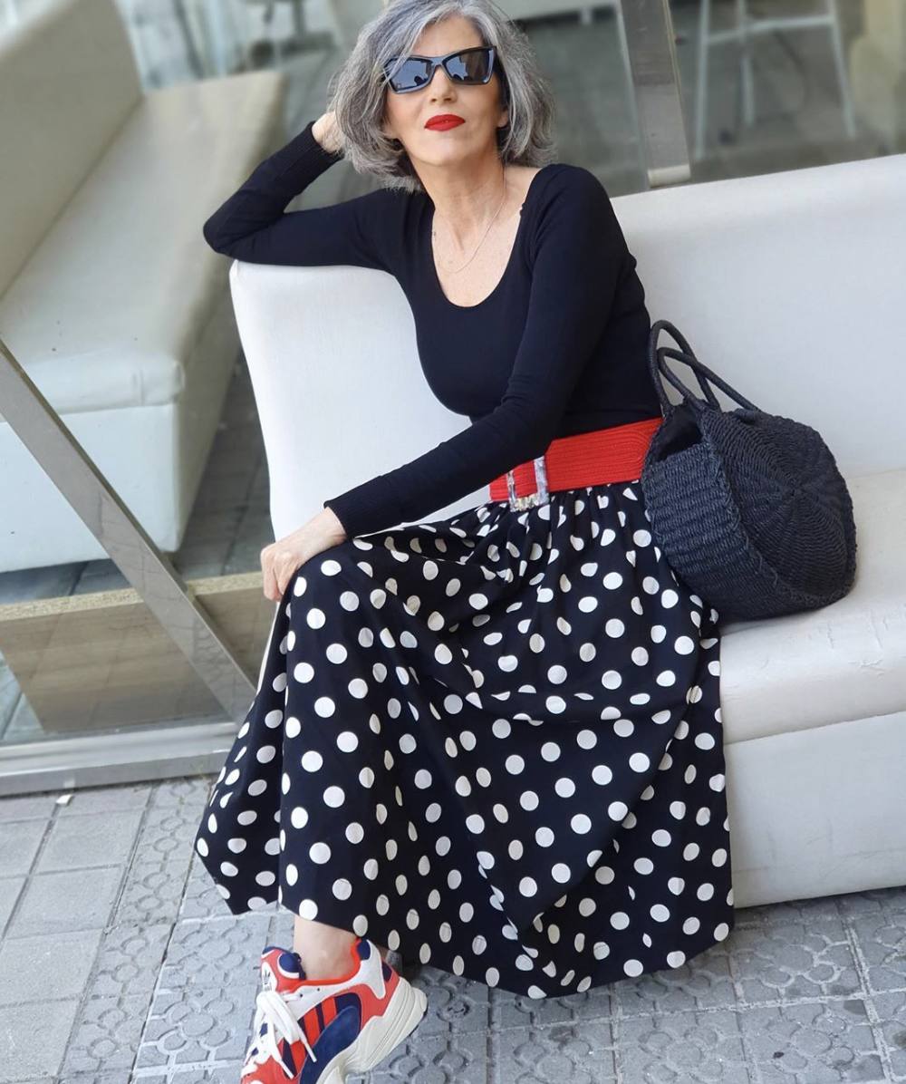 El estampado de lunares es quizás el más atemporal de todos cuantos existen y, a diferencia de las flores, tiene la capacidad de encajar bien tanto en invierno como en verano. Carmen tiene un buen fondo de armario con esta falda de topos en blanco y negro y rompe su clasicismo con complementos arriesgados como unas deportivas tricolor y un cinturón con hebilla XL de carey.