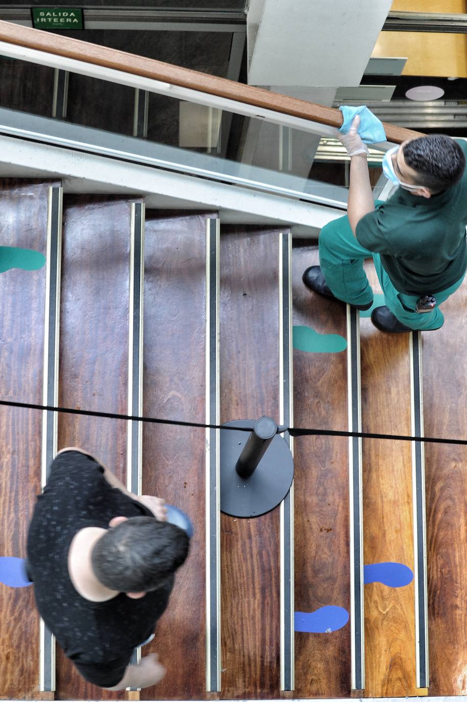 Un operario limpia la barandilla de las escaleras del centro cívico Aldabe, en Vitoria.