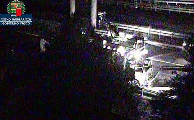 Una grúa, pasadas las 23.30 horas, se dispone a evacuar el camión calcinado. 