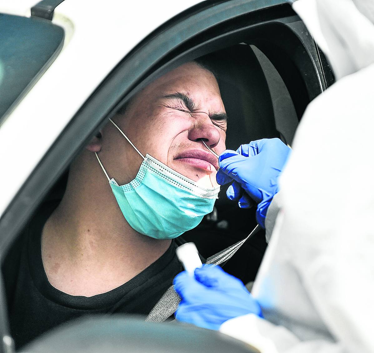 Un sanitario rasca con la sonda de muestras en el fondo del orificio nasal de este conductor.