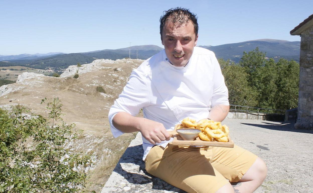 Jon Estívariz posa con un plato de calamares en tempura fuera del local. 