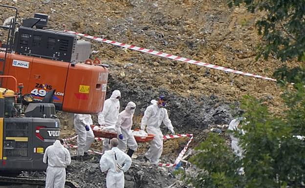 Efectivos de la Ertzaintza trasladan el cuerpo encontrado ayer en la zona de la báscula del vertedero de Zaldibar.