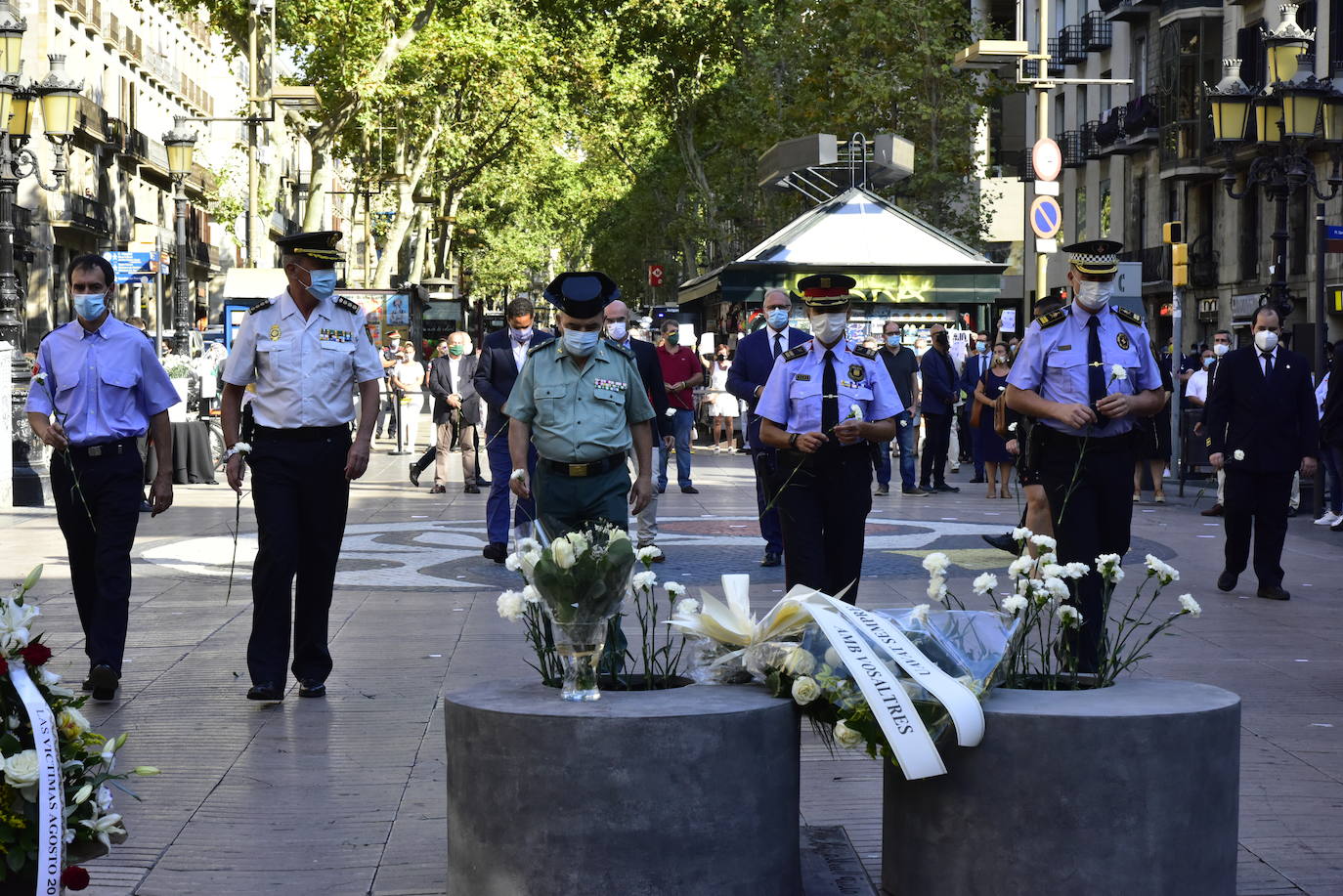 Mossos d'esquadra y un guardia civil guardan un minuto de silencio en recuerdo a las 16 personas fallecidas el 17 de agosto de 2017 y a los más de 150 heridos en los atentados de Barcelona y Cambrils durante el homenaje celebrado en Las Ramblas con motivo del tercer aniversario del ataque.