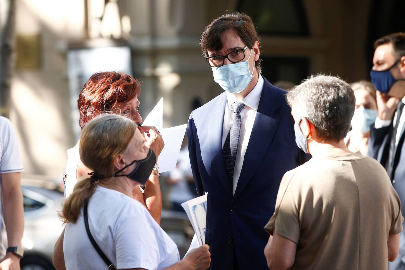 El ministro de Sanidad Salvador illa (c) conversa con asistentes a la ofrenda floral en las Ramblas, celebrada durante el acto de homenaje a las víctimas del atentado terrorista del 17 de agosto de 2017. 