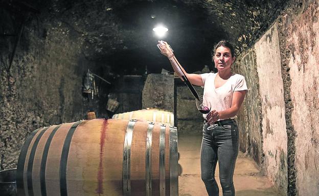 Victoria sirve de la barrica una copa de José Gil, el vino que elabora su novio y que se llama como él.