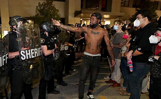 Un hombre se enfrenta a varios policías, este domingo, en Kenosha (Wisconsin).