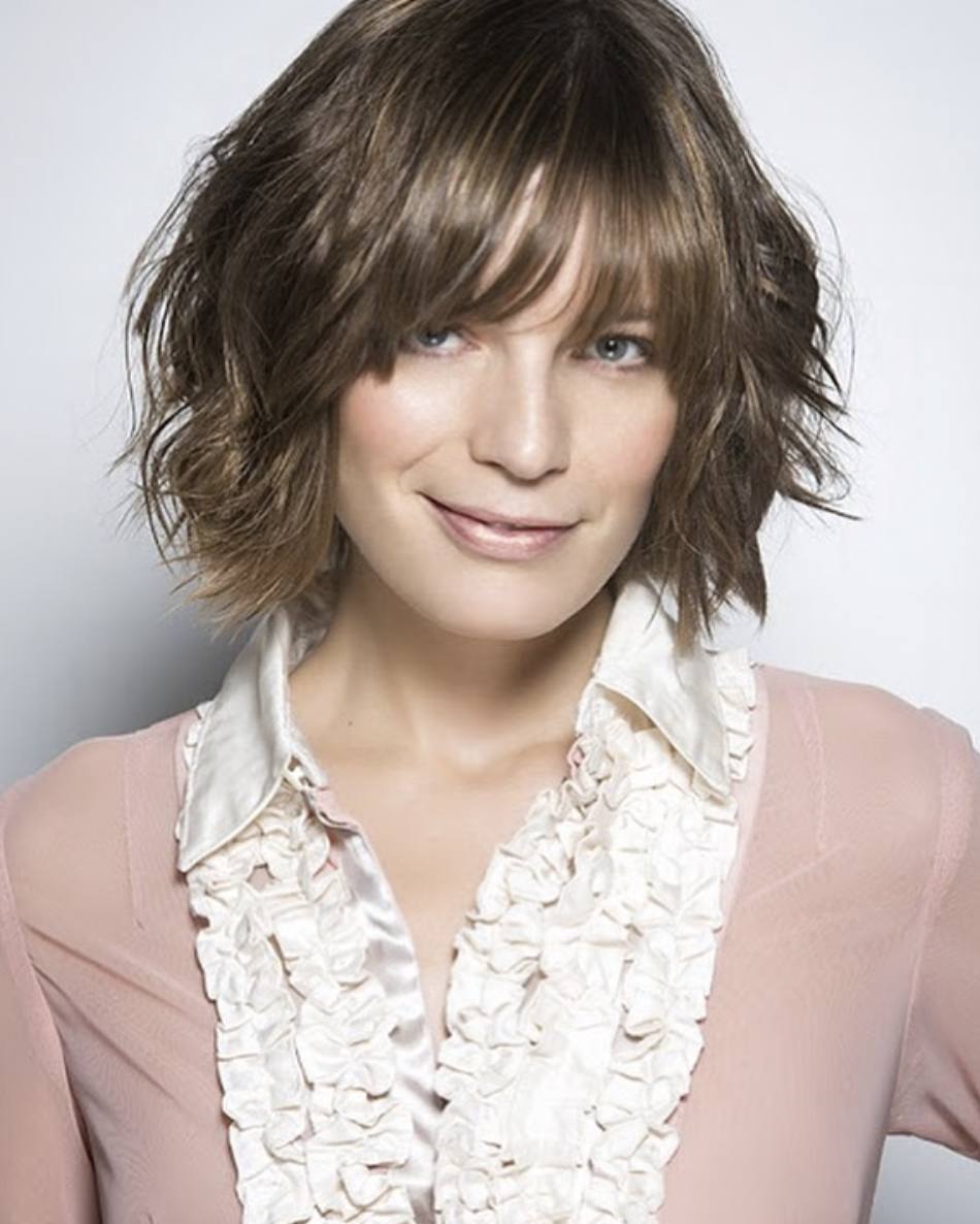 Melena con base recta, capeada y con flequillo. Una opción muy cómoda y práctica. Podremos peinar el cabello con los dedos para conseguir un efecto desenfadado. En la imagen, el look adquiere un rubio oscuro con reflejos castaños.