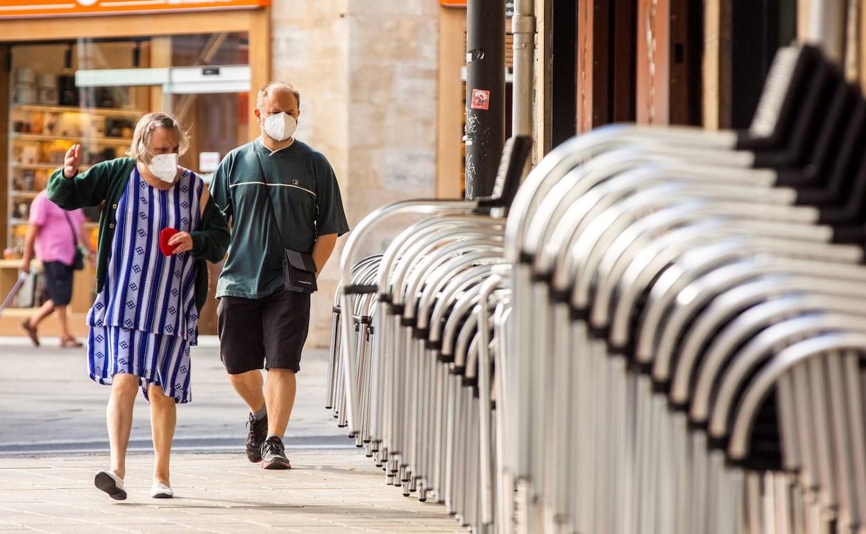 Una mujer pasea junto a un hombre por el centro de Vitoria.