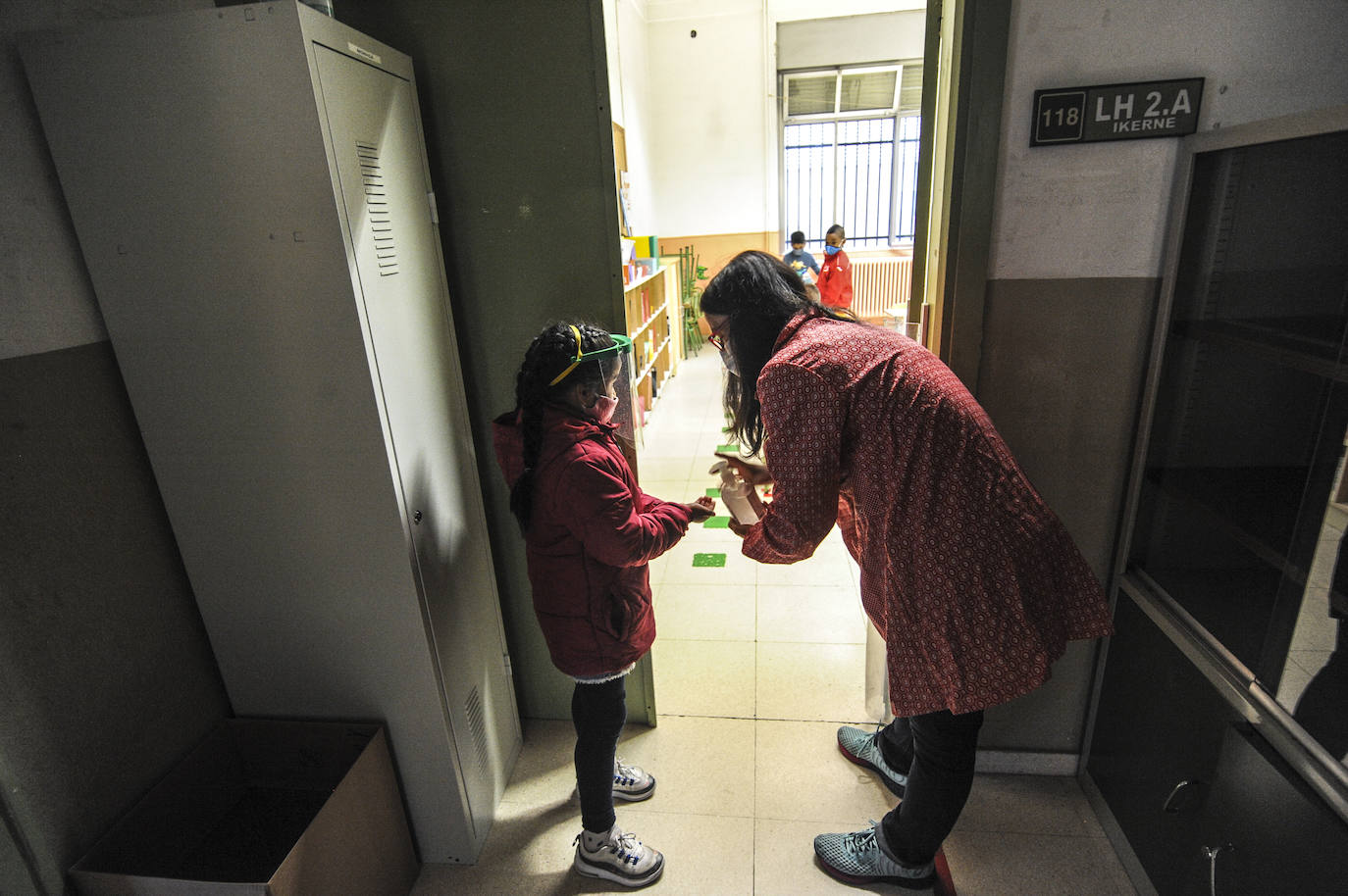 Los pequeños alumnos del colegio Samaniego han aguardado su turno en fila para que sus maestros les pudieran ir tomándoles la temperatura y después se han aplicado hidrogel en las manos.