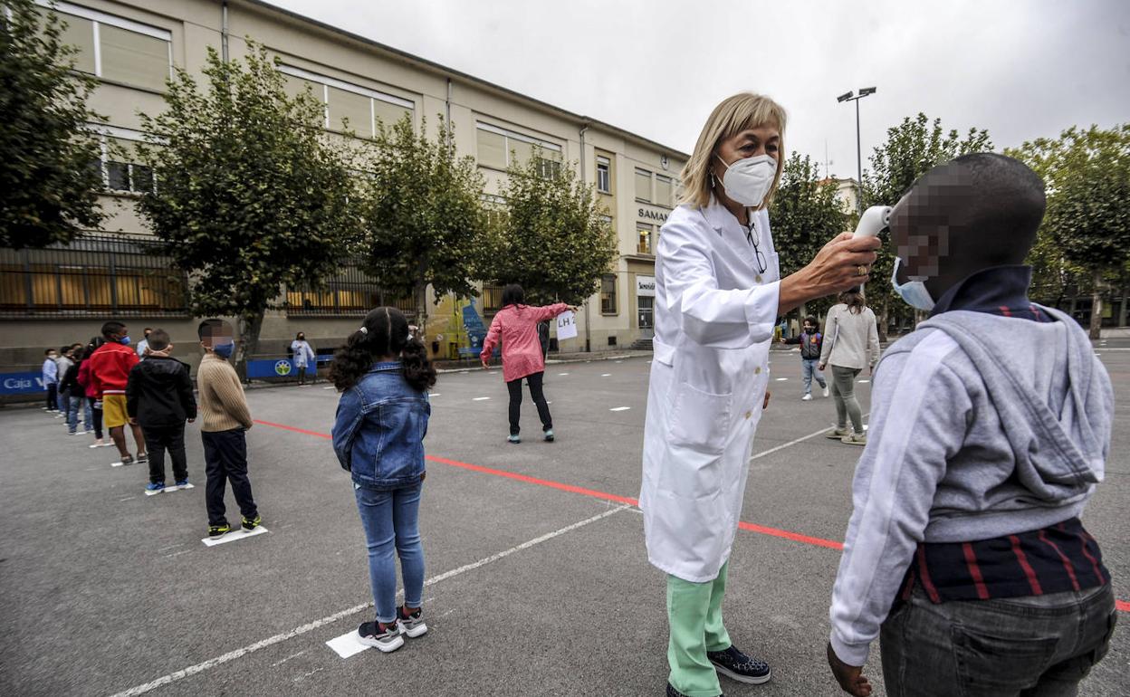 Una profesora del colegio Samaniego toma la temperatura a los alumnos del centro educativo vitoriano.