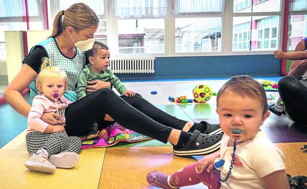 Una maestra atiende a varios niños pequeños en la ikastola San Fidel de Gernika. 