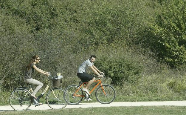 Una pareja recorre Salburua en bicicleta.