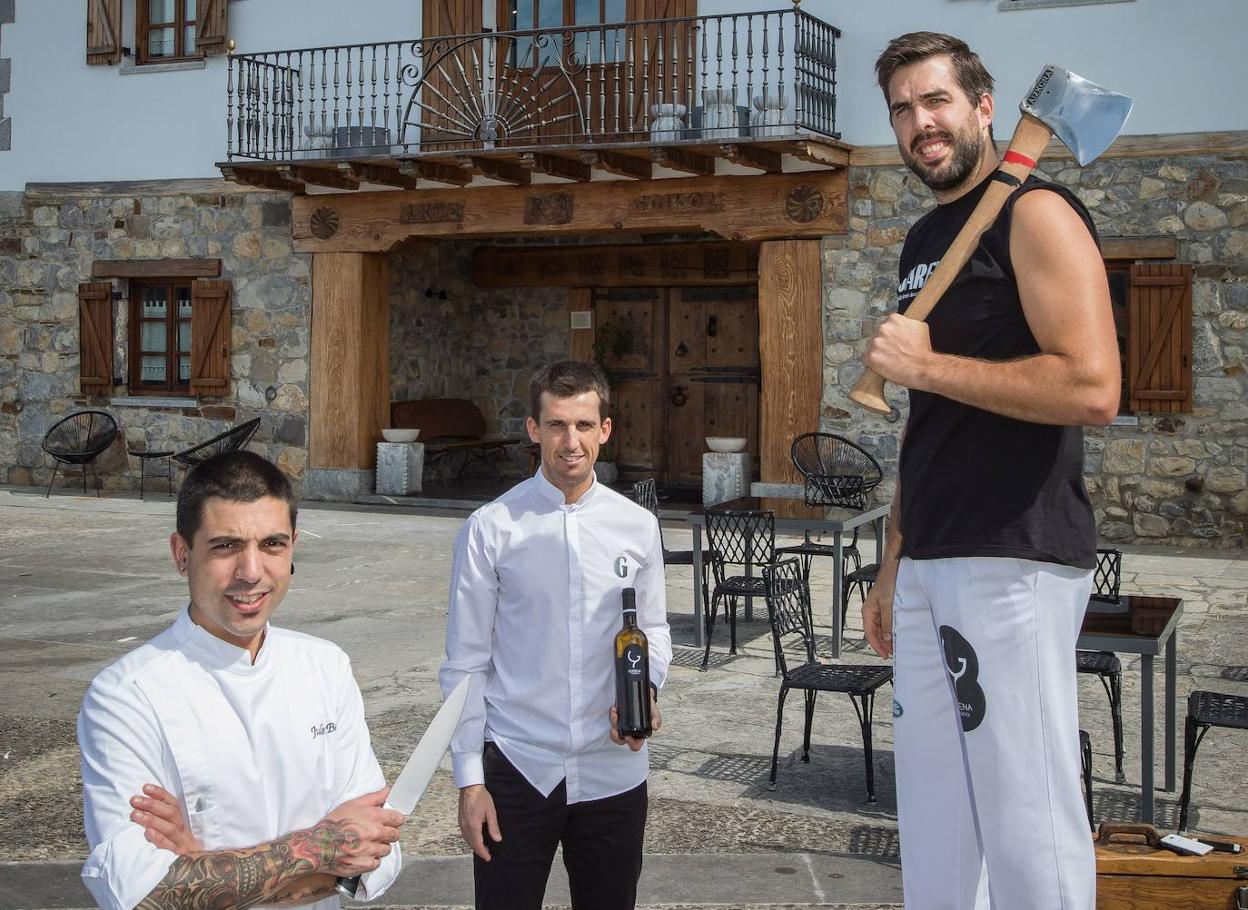 El cocinero Julen Baz, el responsable de la sala, Imanol Artetxe, y su socio, el aizkolari Aitzol Atutxa, frente al caserío de Lamindao donde han abierto Garena. 