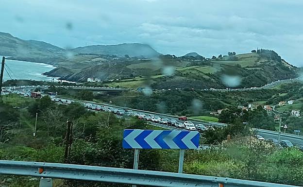 Imagen principal - Retenciones kilométricas en dirección Santander./ El camión ha roto uno de los guardaraíles./