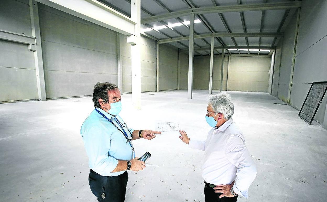 Alberto Arriarán, jefe de mantenimiento de Osakidetza, y Martín Solaun, técnico de Farmacia, en el pabellón que servirá de almacén. 