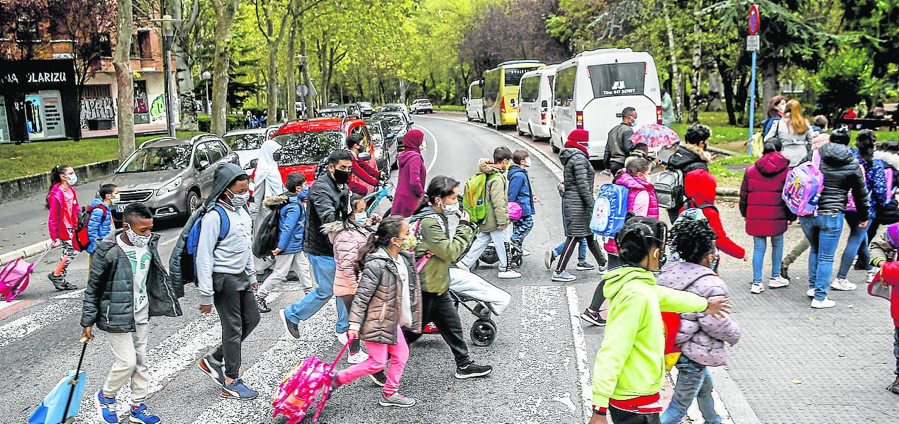 Escolares cruzan por el paso de peatones la calle Iturritxu en el tramo que se desdobla.