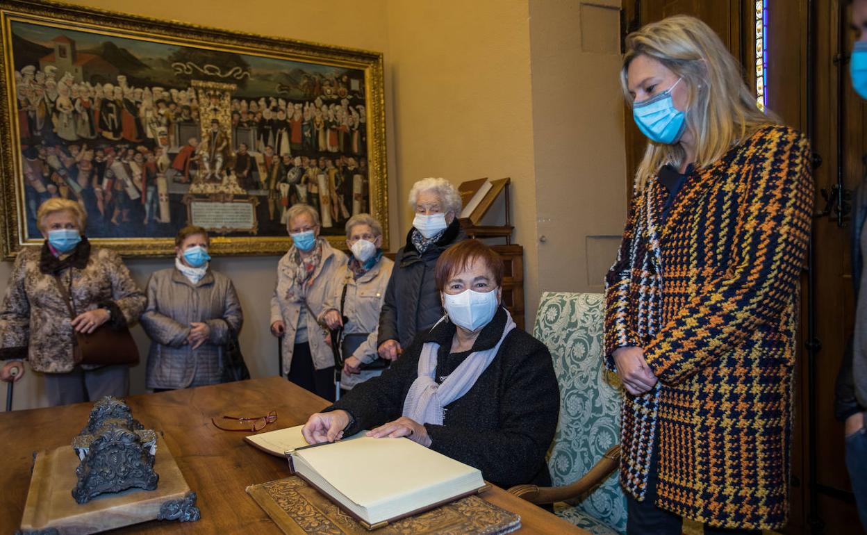 Las parcicioantes en el acto firman en el libro de honor.