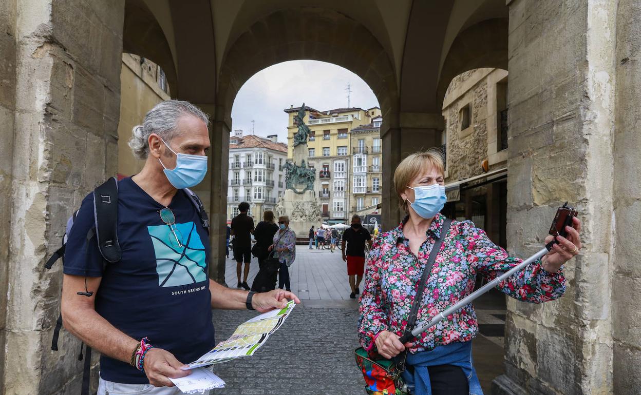 Turistas ajenos a la información, en la plaza de España de Vitoria. 