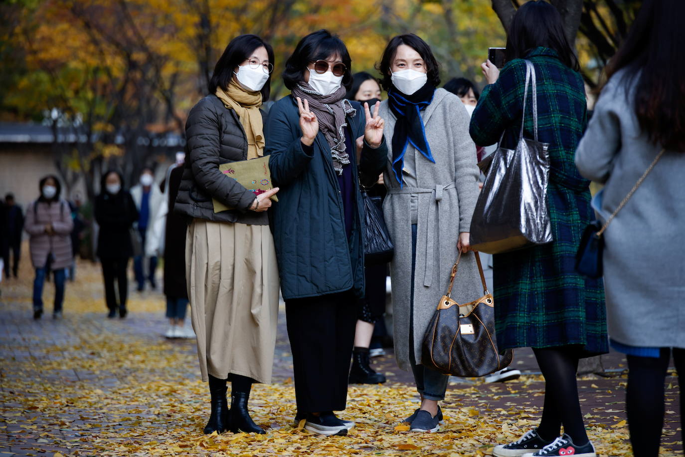 Mujeres posan para fotografías mientras disfrutan de un día de otoño en medio de la pandemia de la enfermedad por coronavirus (COVID-19) en Seúl, Corea del Sur.